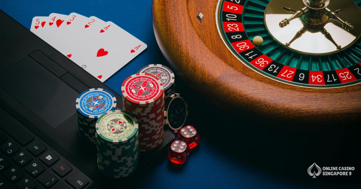 Online casino setup with roulette wheel, poker chips, playing cards, and laptop representing casino gaming in Singapore